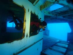 Scuba diver swimming through a window on the Vandenberg wreck in Key West